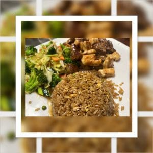 A plate of fried rice, stir-fried vegetables, and grilled meat, framed by a blurred border effect.