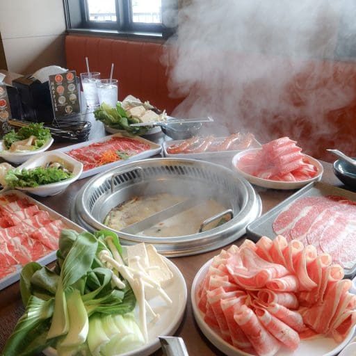 hot pot meal with meats and broth on a table from happy lamb